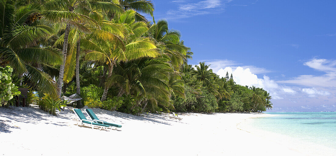 Ein unberührter Strand mit zwei Liegestühlen; Rarotonga, Cookinseln