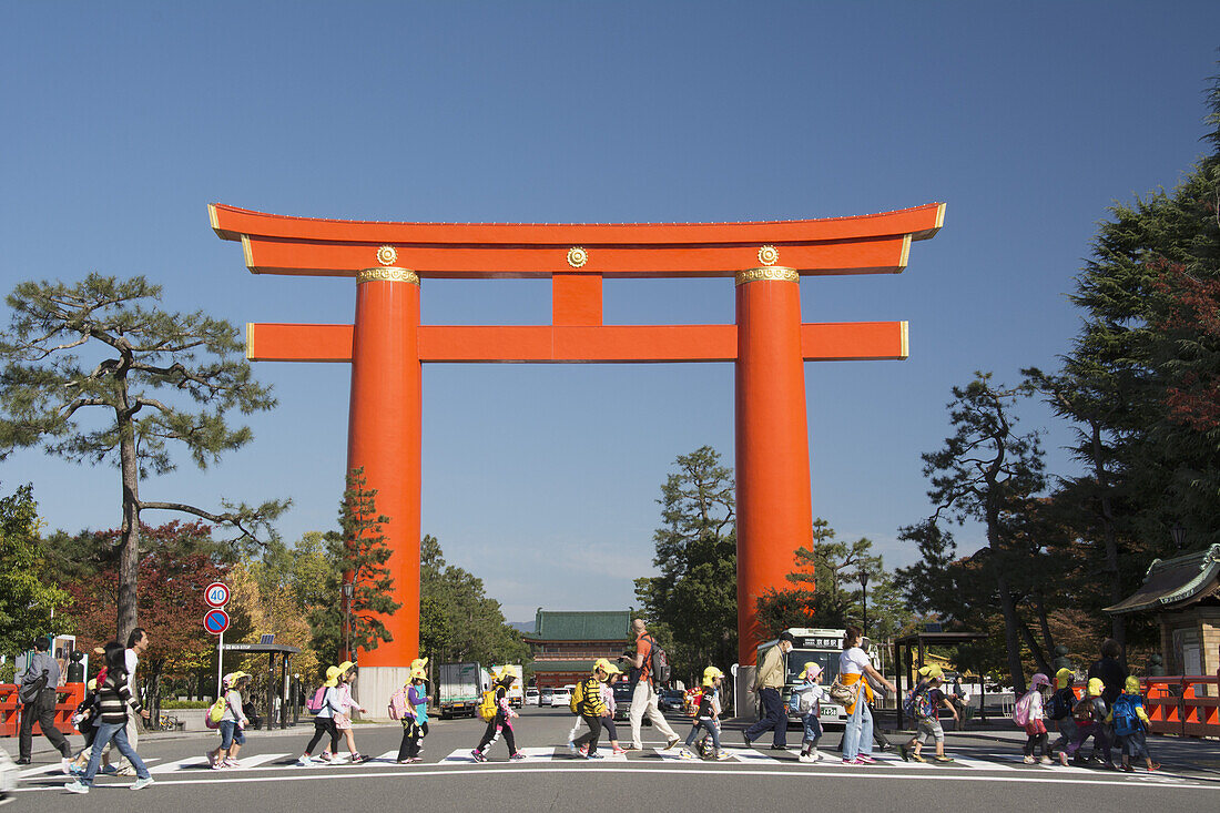 Großes Tori-Tor und Fußgänger, die die Straße überqueren; Kyoto, Japan