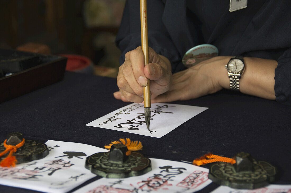 Japanese Temple Employee Doing Calligraphy; Uji, Kyoto, Japan