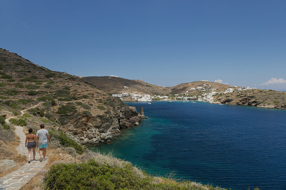 Ein Paar, das einen Pfad in Richtung Faros im Südosten von Sifnos entlanggeht; Sifnos, Kykladen, Griechische Inseln, Griechenland