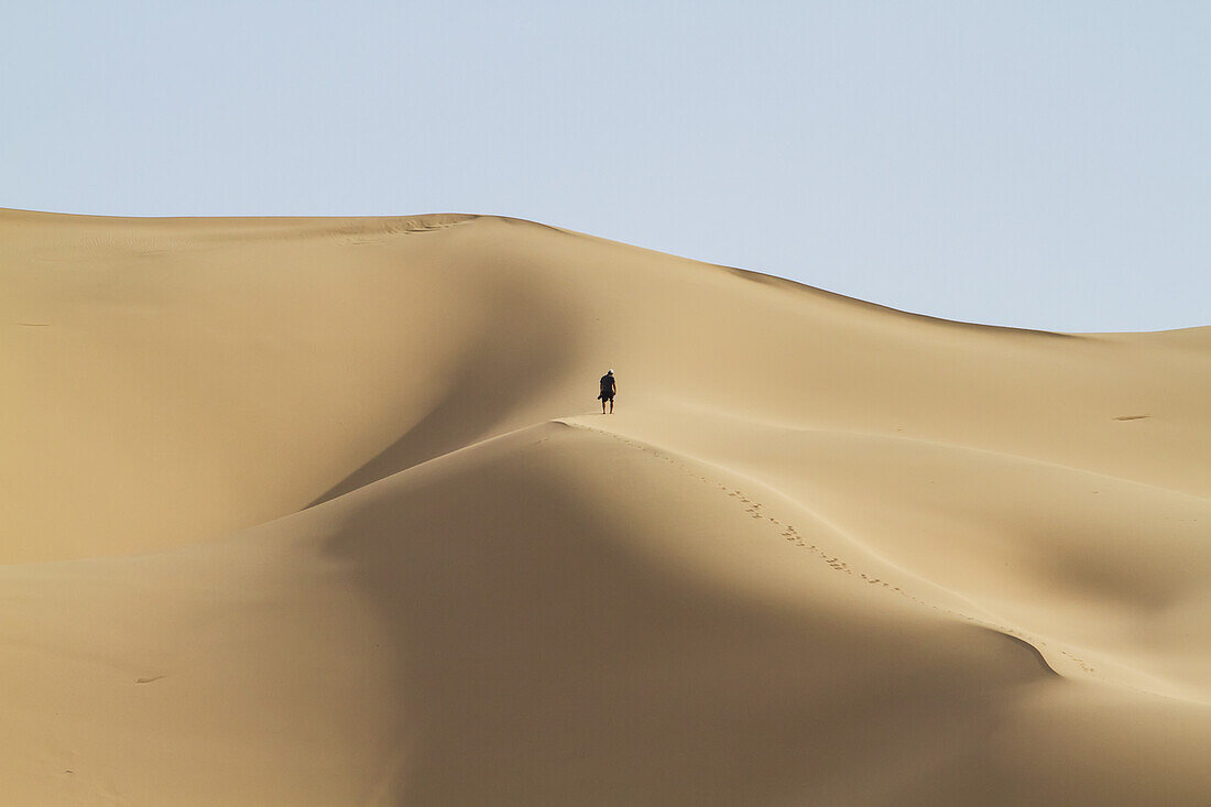 Mann auf den Sanddünen von Khongoryn Els, Gobi-Gurvansaikhan-Nationalpark, vEmnv?govi-Provinz, Mongolei