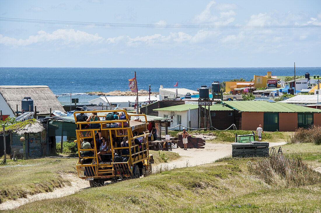 Reisebus transportiert Passagiere auf der Sandstraße entlang der Küste zu Unterkünften; Cabo Polonio, Uruguay