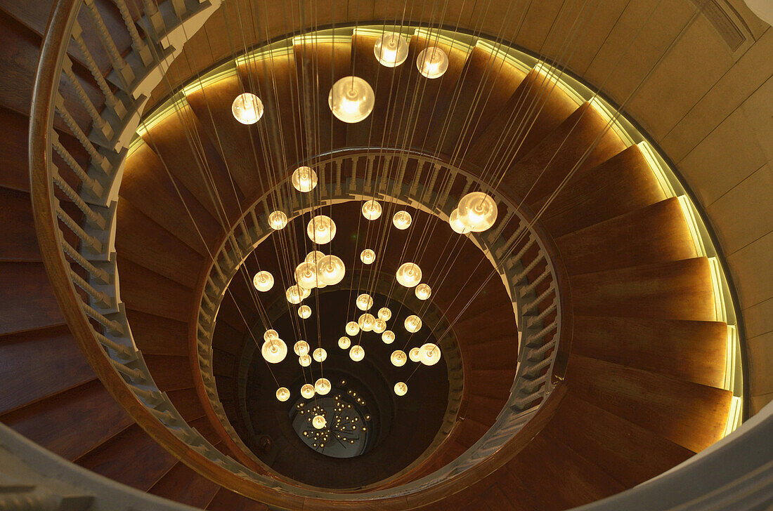 Spindeltreppe mit Lichtern im Kaufhaus Heal's, Tottenham Court Road; London, England.