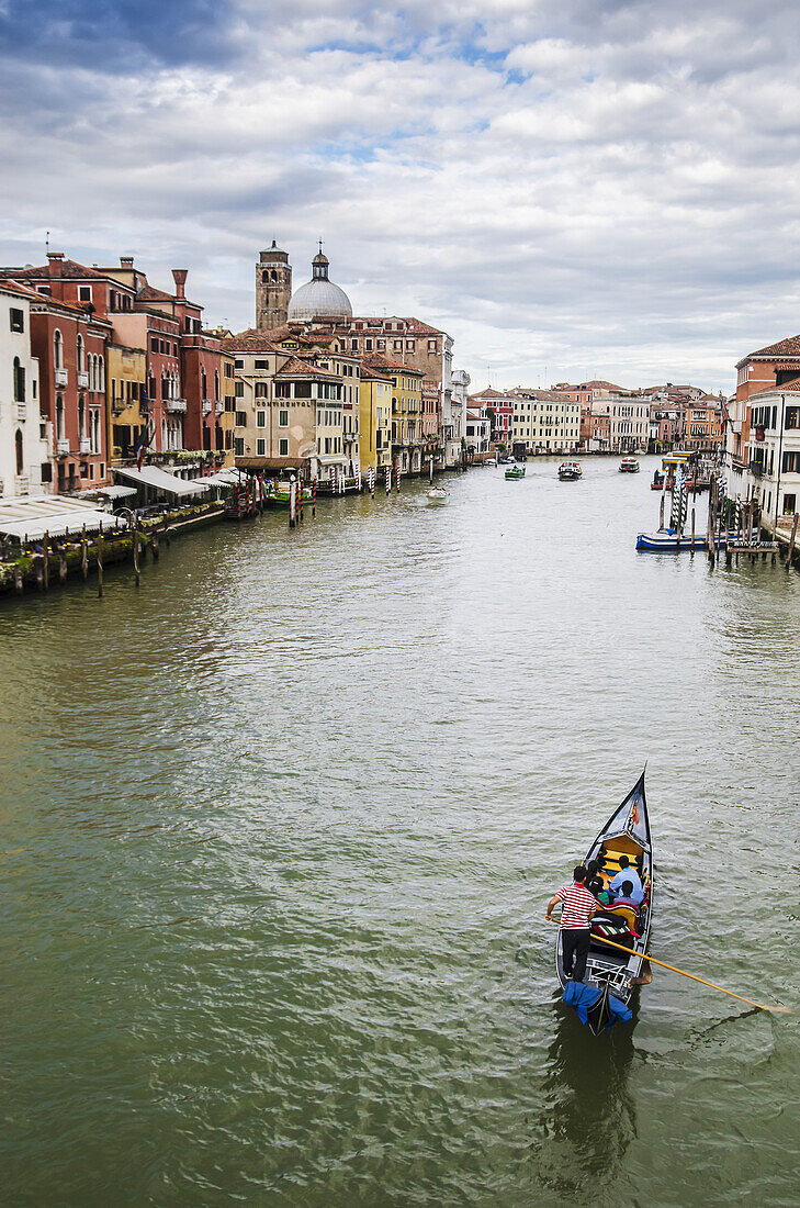 A Gondola Makes It's Way Down The Grand Canal; Venice, Italy