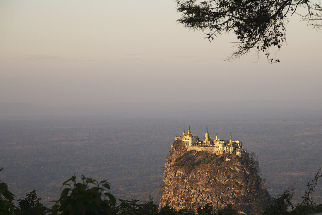 Berühmtes Taung Kalat Kloster in der Nähe des Mount Popa auf einem Vulkanpfropfen gelegen und bei Sonnenuntergang vom Mount Popa Resort aus gesehen; Myanmar