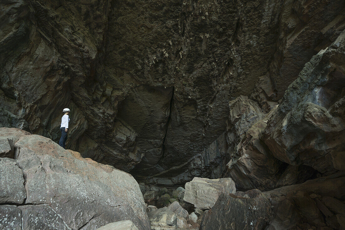 A Woman Standing At The Entrance To A Large Cave In Toro Toro National Park; Bolivia