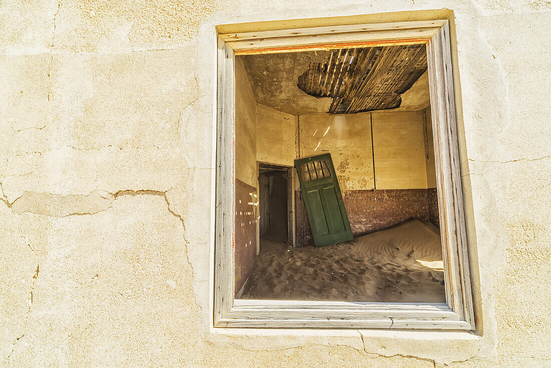 Sand in den Räumen eines farbenfrohen und verlassenen Hauses; Kolmanskop, Namibia