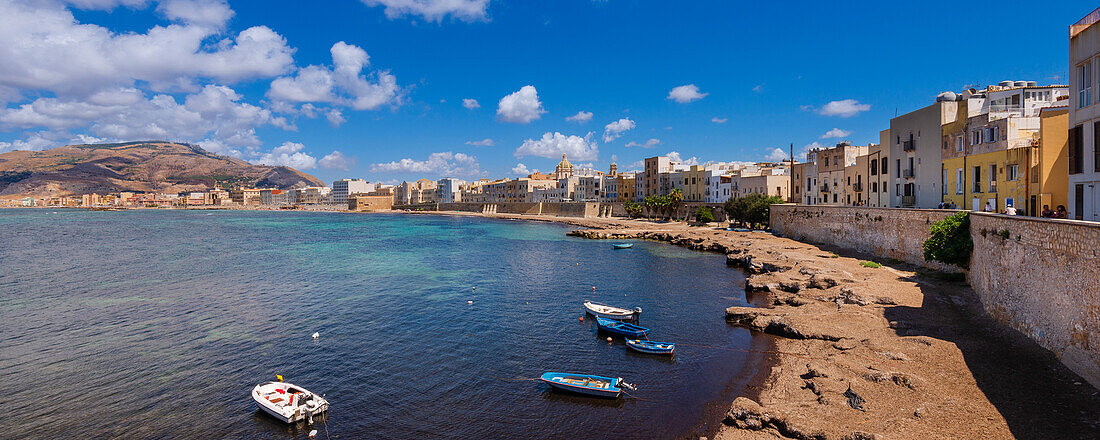 Kleine Boote am Ufer der Skyline von Trapani mit alten, steinernen Gebäuden und der Ufermauer; Trapani, Sizilien, Italien