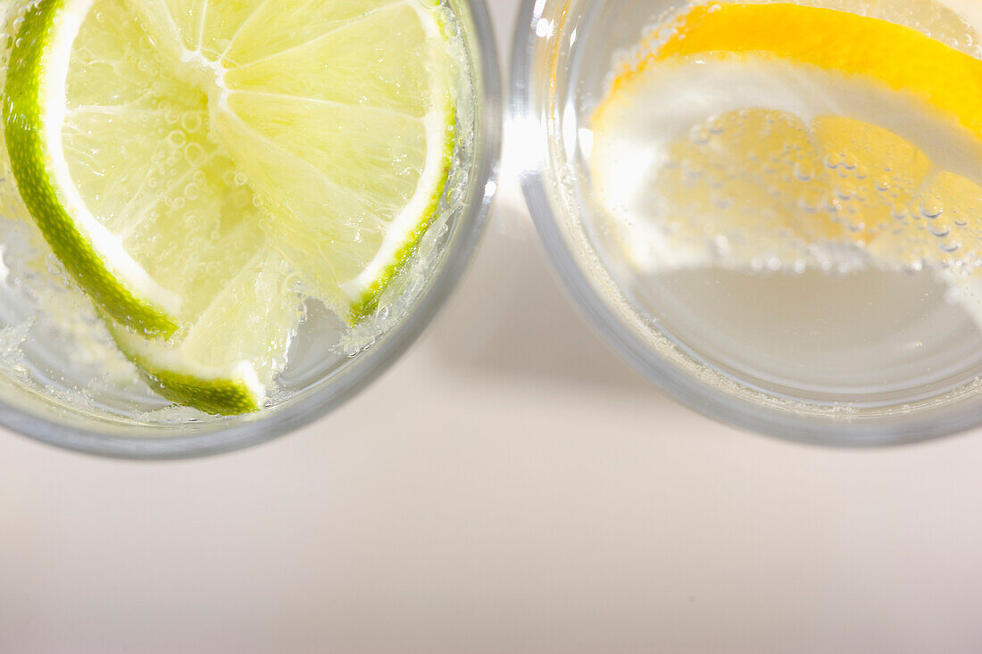 Extreme Nahaufnahme von zwei Gläsern Sprudelwasser mit Zitrone und Limette