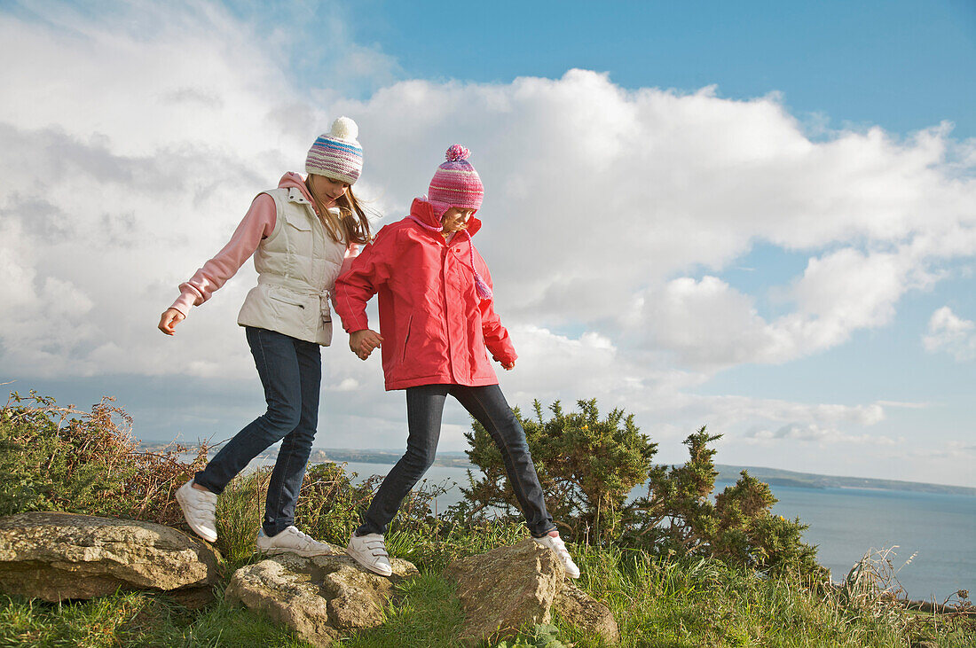 Zwei junge Mädchen wandern auf einer Klippe