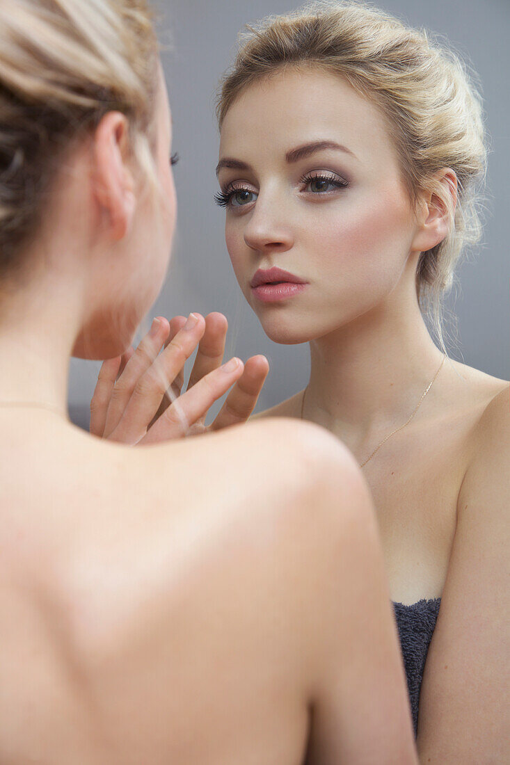 Young Woman Looking in Mirror
