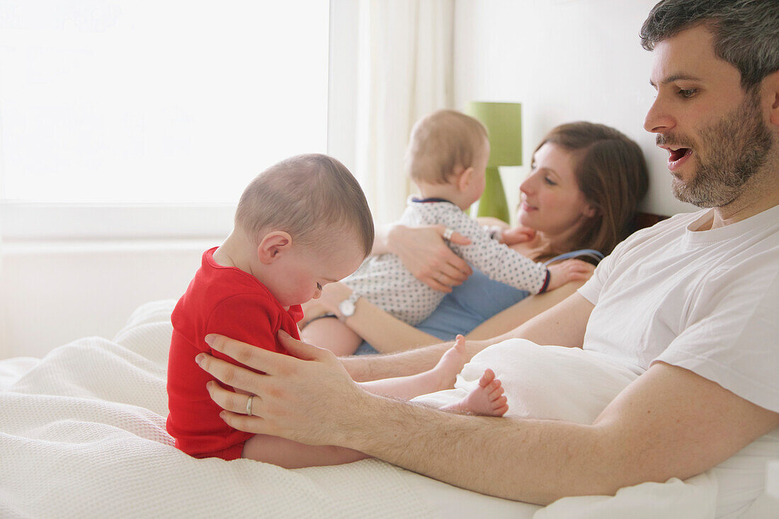 Pärchen im Bett mit Baby-Zwillingen