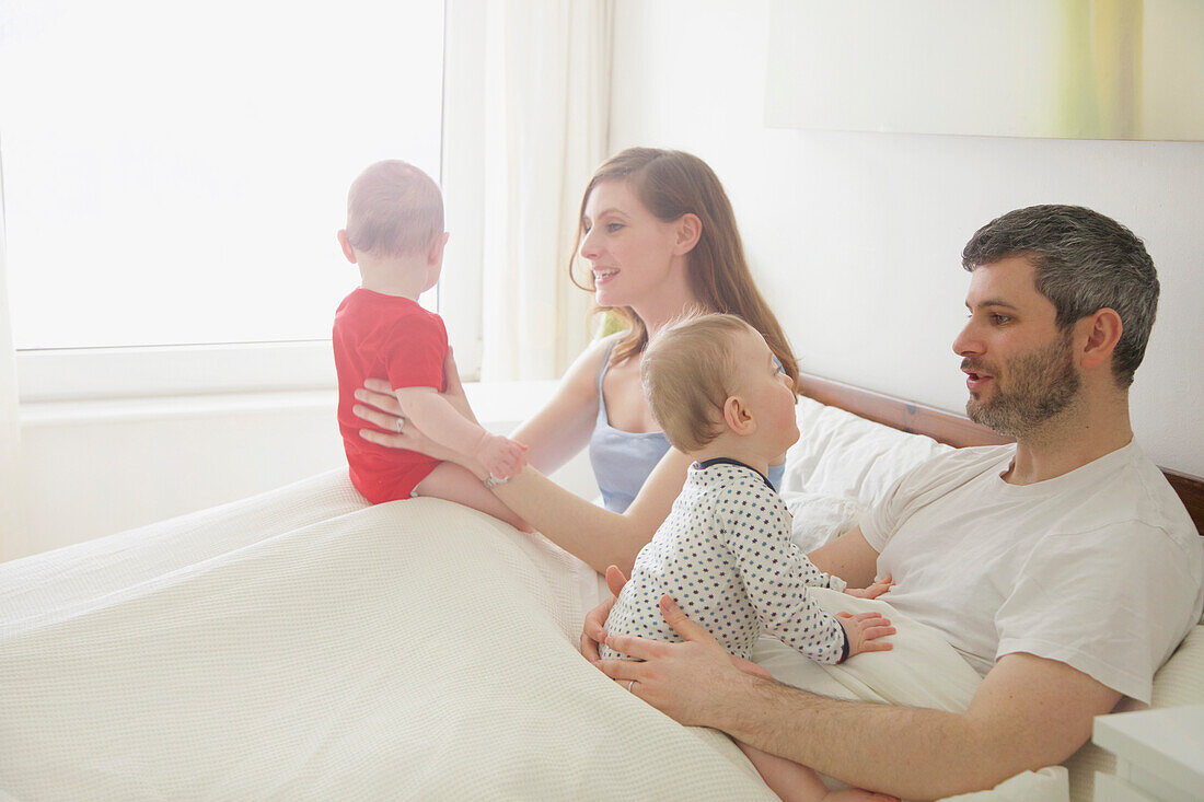 Pärchen im Bett mit Baby-Zwillingen