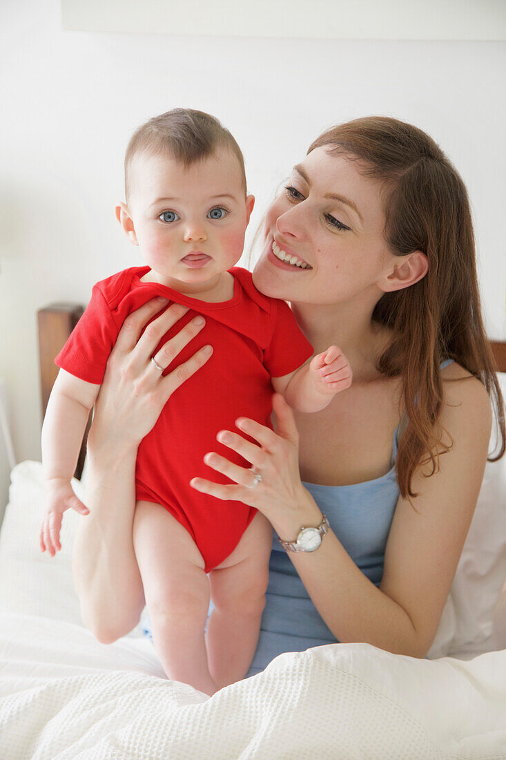 Mother in Bed Holding Baby Girl