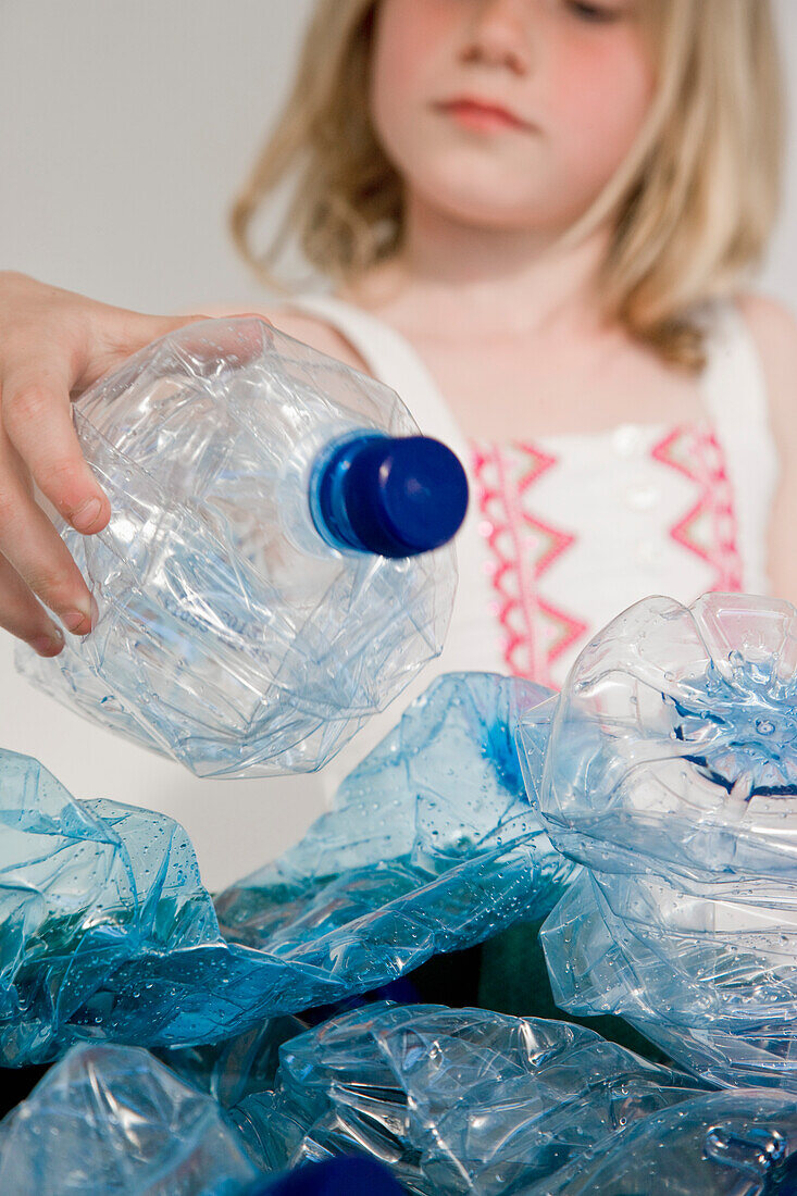 Junges Mädchen recycelt Plastikwasserflaschen