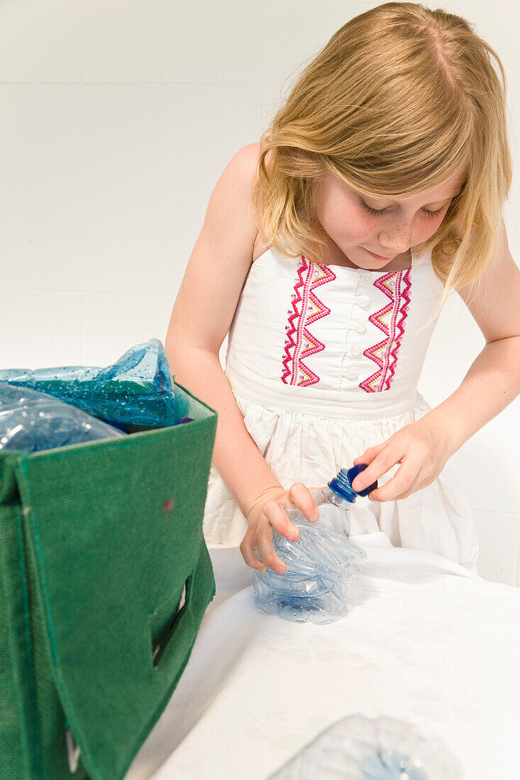 Young Girl Recycling Plastic Water Bottles