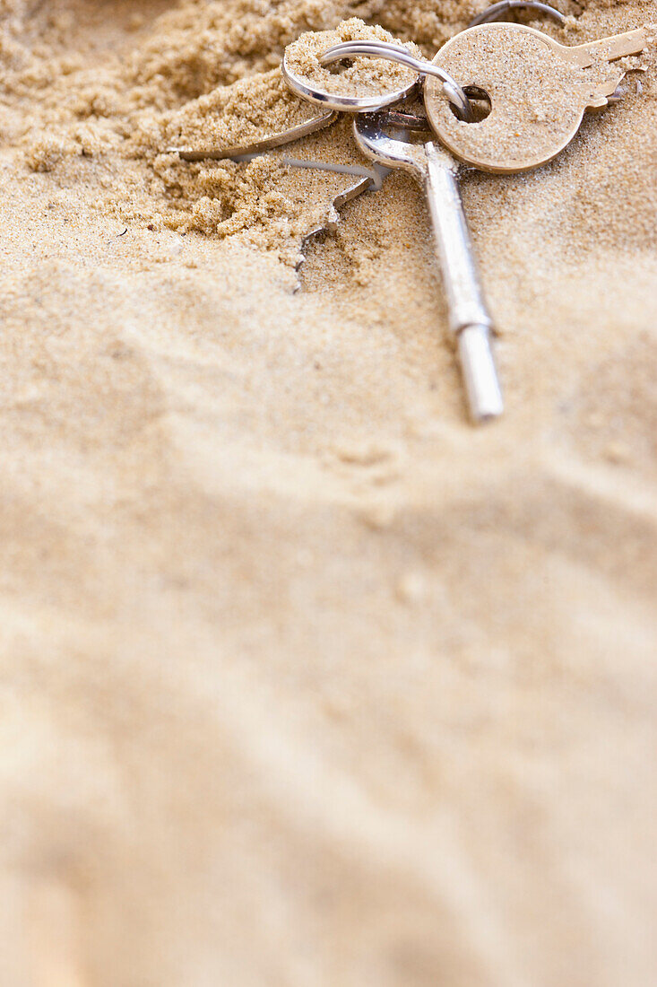 Nahaufnahme von Schlüsseln im Sand
