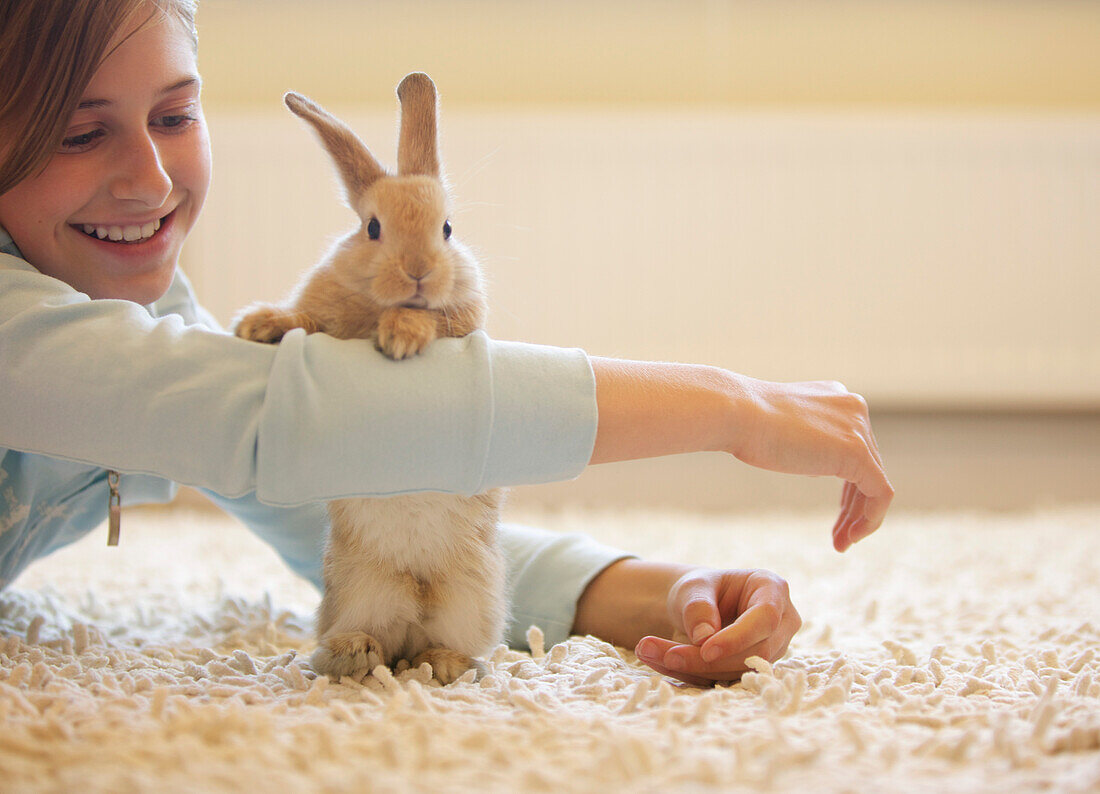 Kaninchen lehnt sich an den Arm eines Mädchens