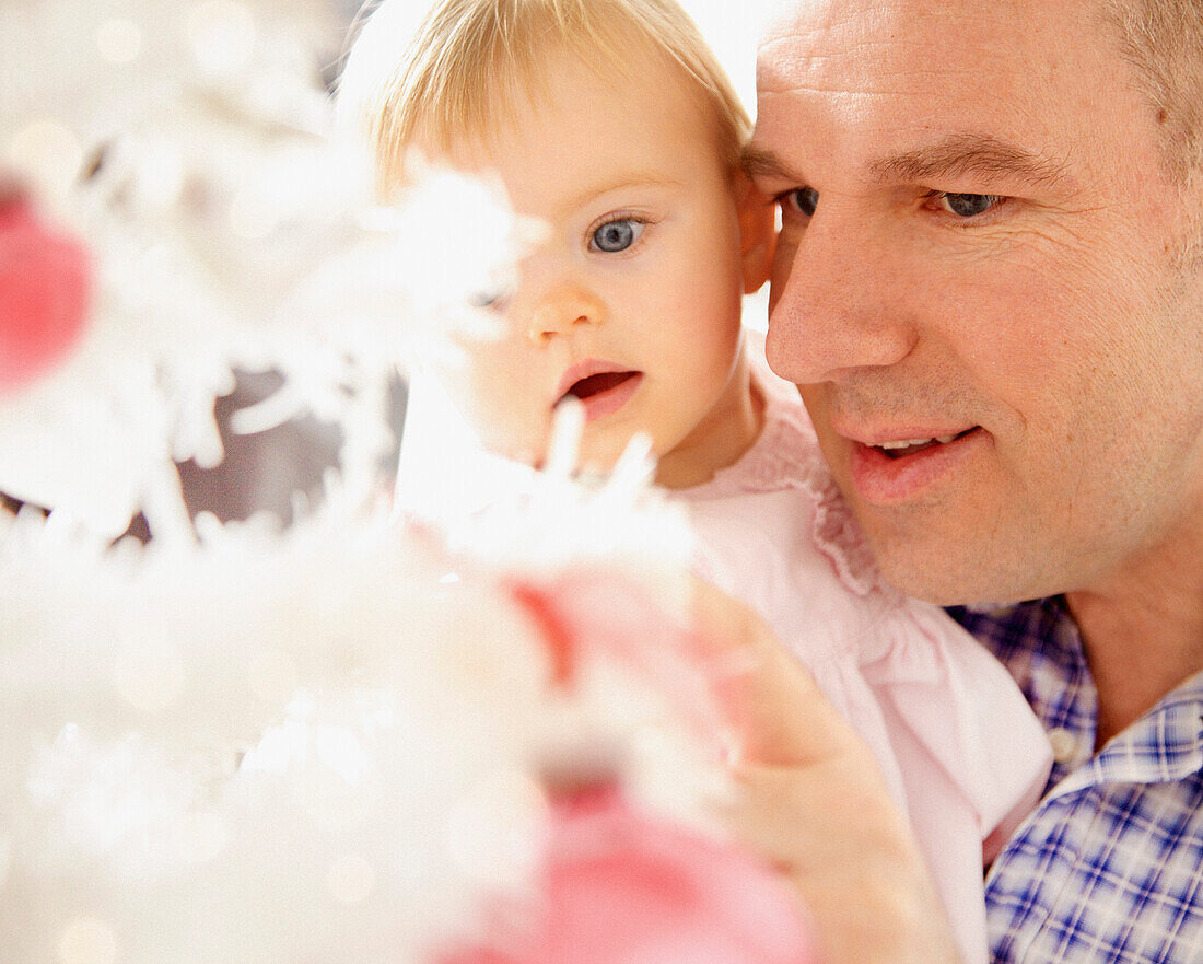 Father and Baby Daughter Looking at Christmas Tree