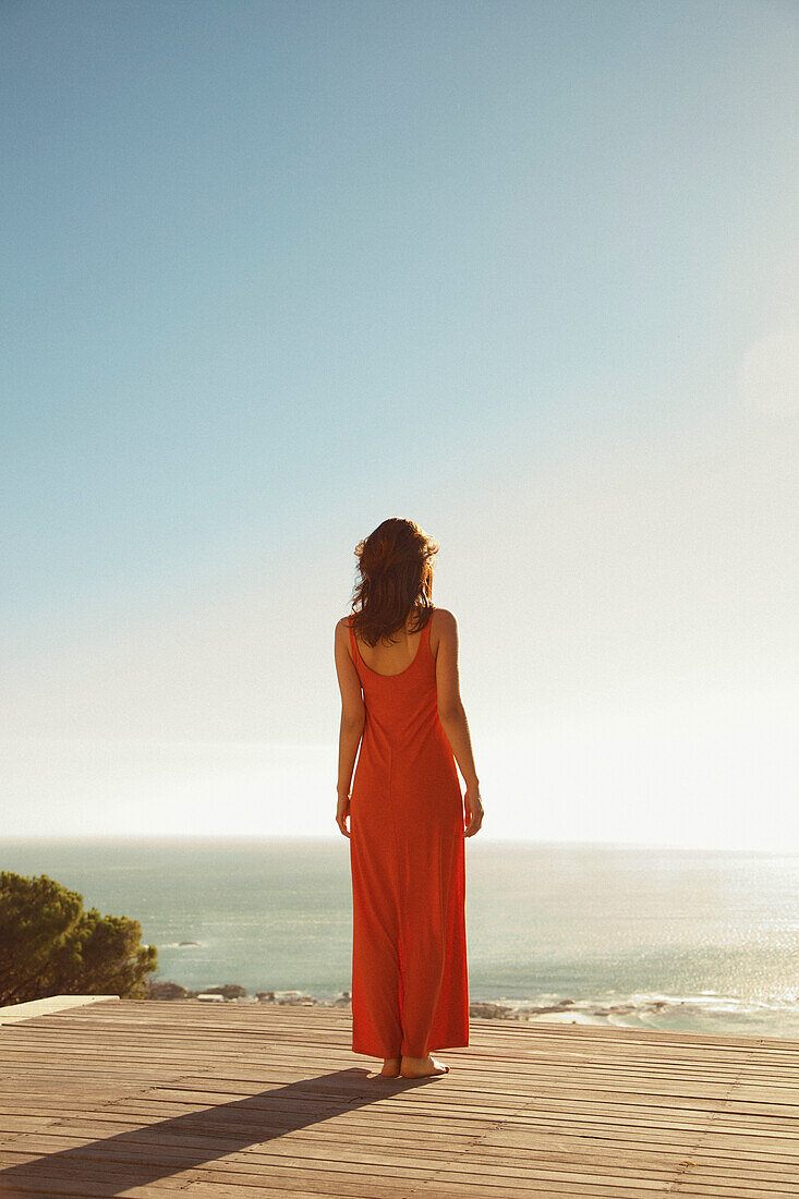 Rückenansicht einer Frau mit Blick auf den Ozean