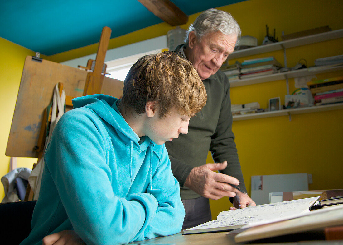 Grandfather showing grandson a drawing book