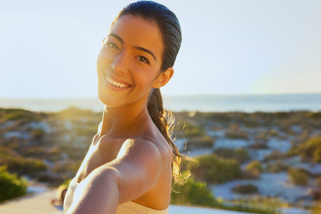 Smiling Young Woman with Arm Raised, Close-up View