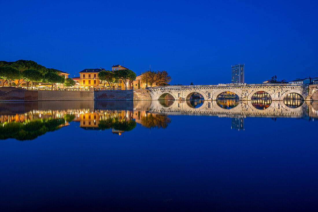 View of Ponte di Tiberio reflecting in Rimini Canal in Borgo San Giuliano district at dusk, Rimini, Emilia-Romagna, Italy, Europe