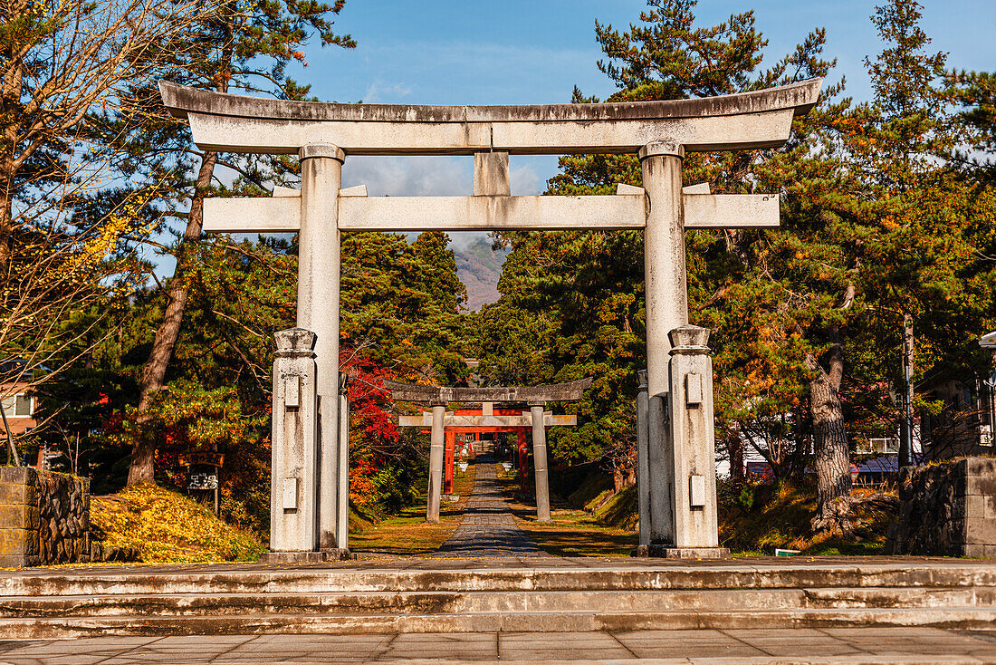 Big stone torii gate framing more distant gates on the foot of mount Iwaki. Iwakiyama-jinja Shrine Mt Iwaki Shrine in Hirosaki, Japan