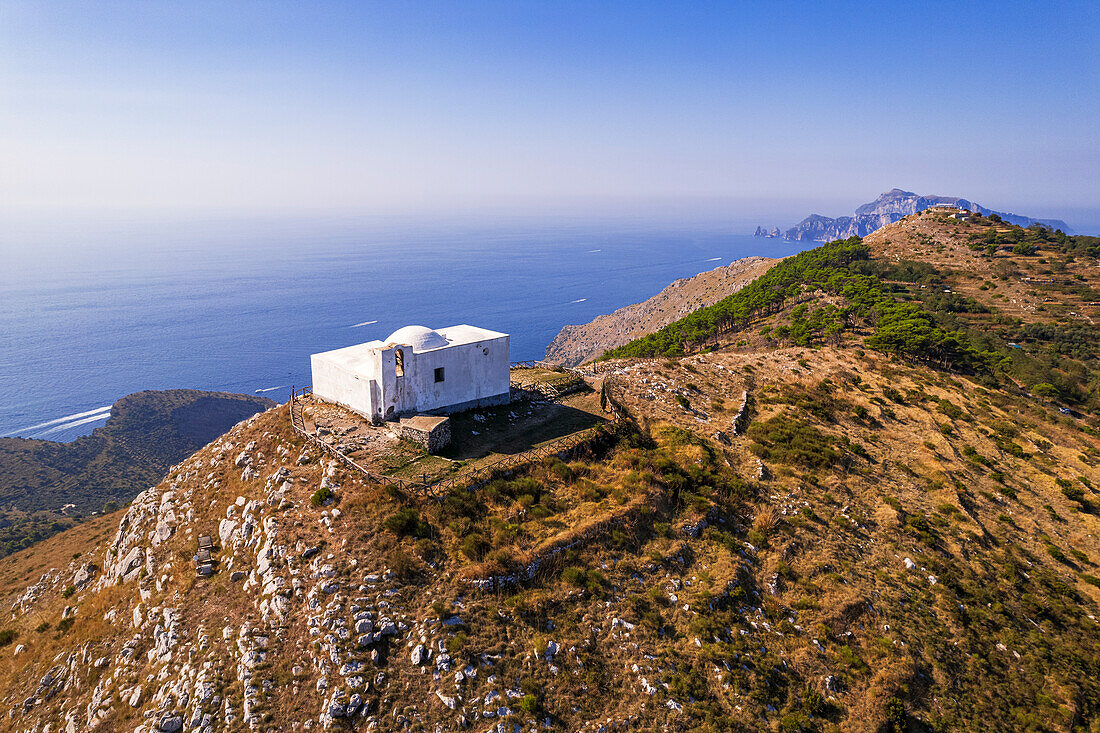 Luftaufnahme der weißen Kapelle von San Costanzo auf dem Gipfel eines Berges, der das Meer der Amalfiküste umgibt, Punta Campanella, Gemeinde Massa Lubrense, Provinz Neapel, Region Kampanien, Italien, Europa