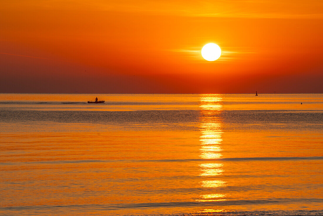 Blick auf den Sonnenaufgang, der sich im Meer spiegelt, vom Strand von Rimini aus, Rimini, Emilia-Romagna, Italien, Europa