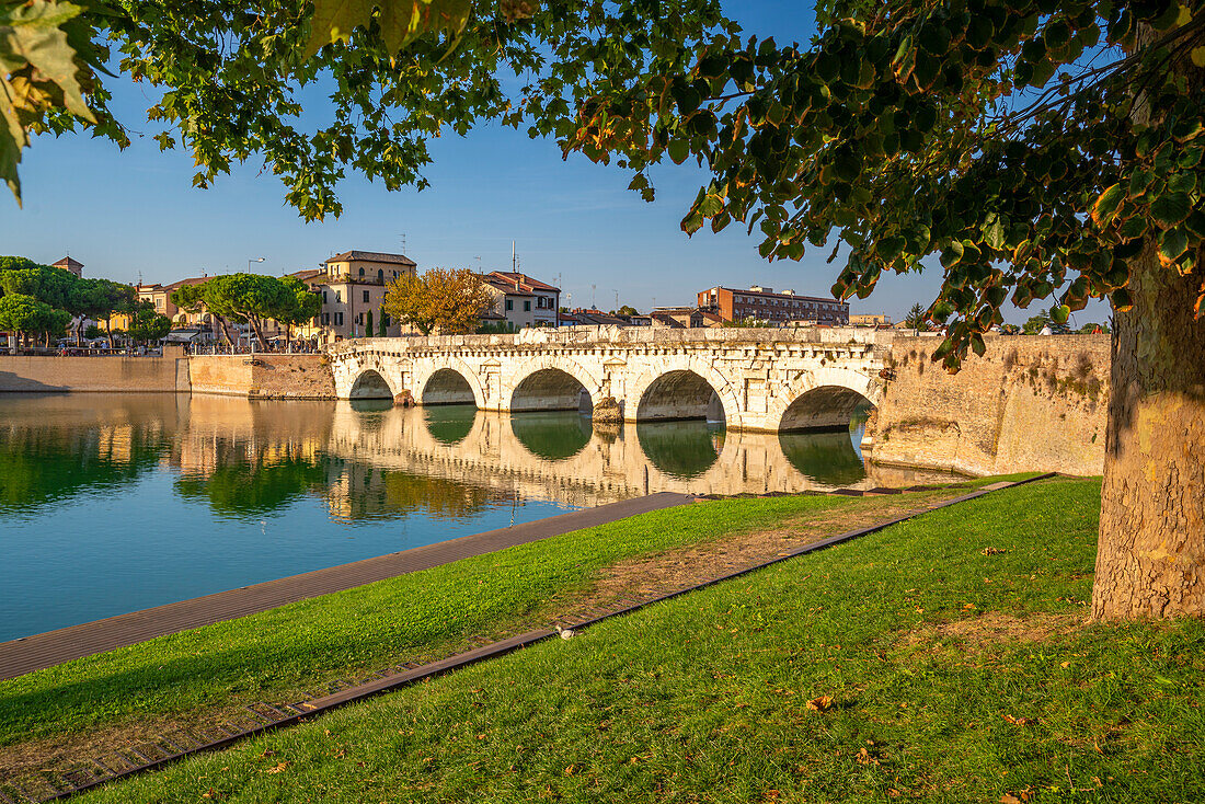 View of Ponte di Tiberio reflecting in Rimini Canal, Rimini, Emilia-Romagna, Italy, Europe