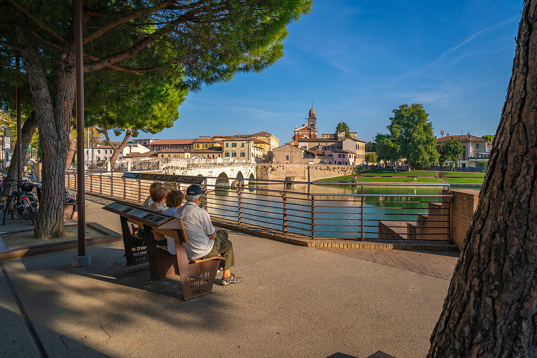 Einheimische betrachten die Ponte di Tiberio, die sich im Kanal von Rimini spiegelt, von Borgo San Giuliano, Rimini, Emilia-Romagna, Italien, Europa