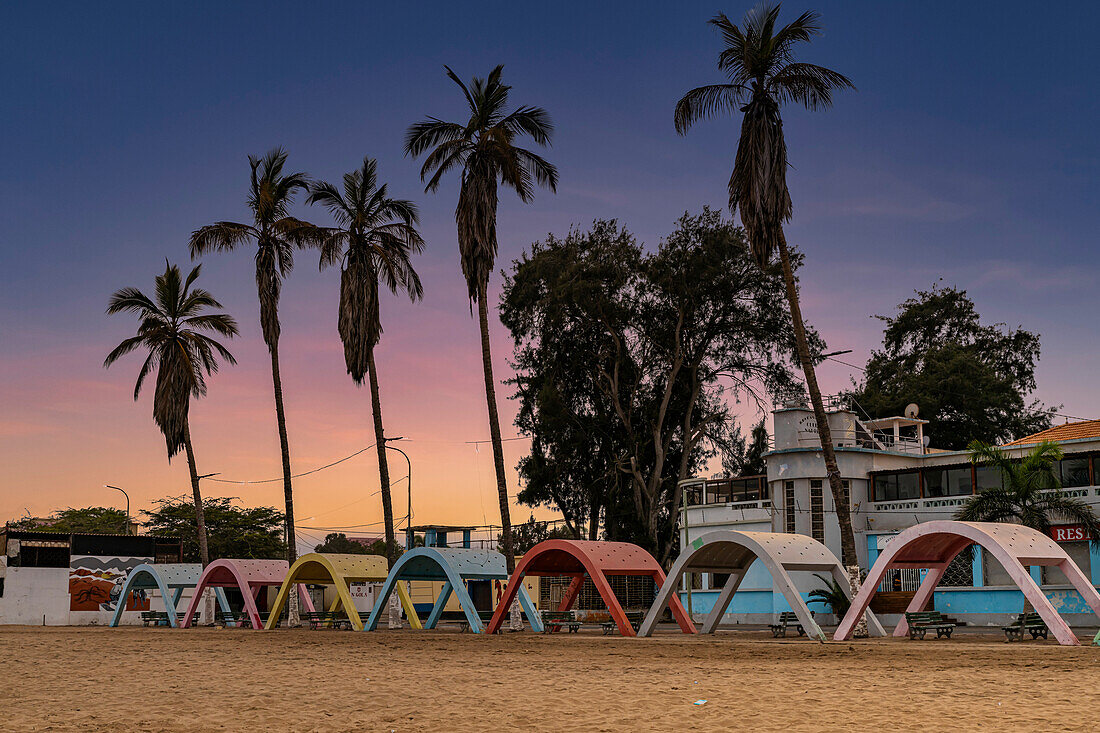 Blaue Stunde über dem Strand mit kolonialen Betonstrandschirmen in der Stadt Namibe, Angola, Afrika