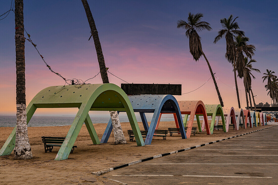 Blue hour over the beach with colonial concrete beach shades in the town of Namibe, Angola, Africa