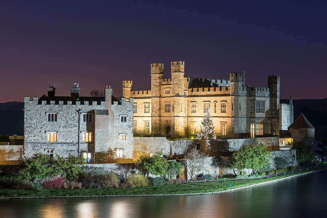 Leeds Castle and moat at night with decorated Christmas tree, near Maidstone, Kent, England, United Kingdom, Europe