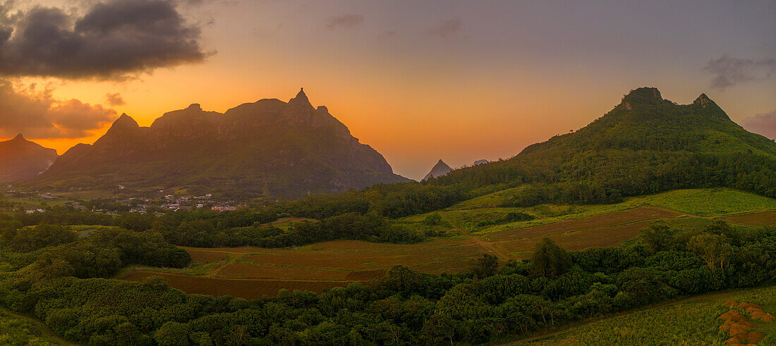 Blick auf einen goldenen Sonnenuntergang hinter dem Long Mountain und einem Flickenteppich aus grünen Feldern, Mauritius, Indischer Ozean, Afrika
