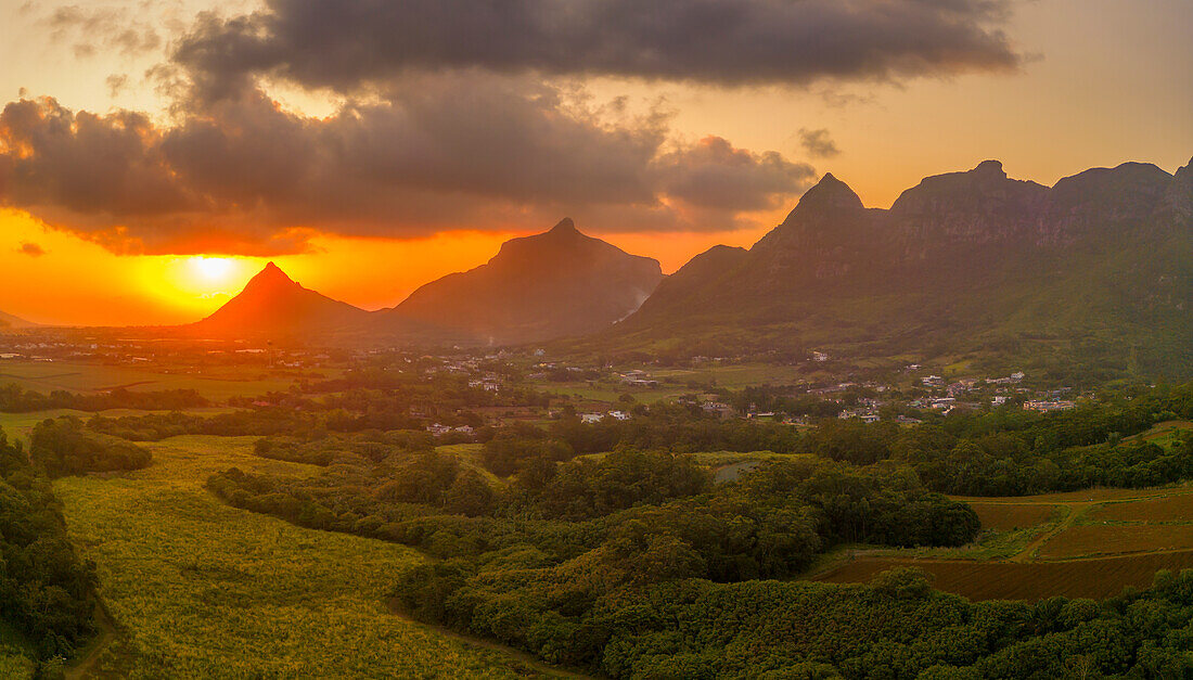 Blick auf einen goldenen Sonnenuntergang hinter dem Long Mountain und einem Flickenteppich aus grünen Feldern, Mauritius, Indischer Ozean, Afrika