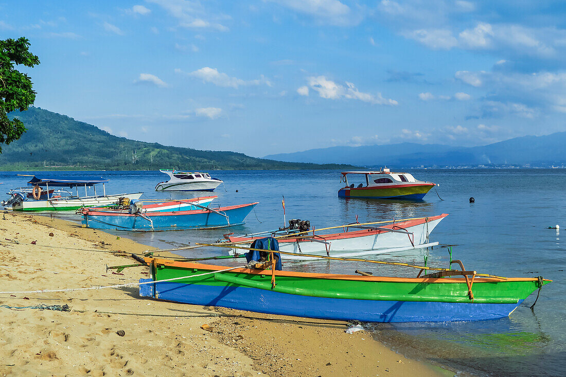 Outrigger canoes and launches at this coral fringed holiday island and scuba diving destination, Bunaken Island, Sulawesi, Indonesia, Southeast Asia, Asia