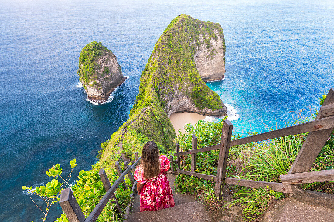 Rear view of woman admiring T-Rex cliffs at Kelingking beach, Nusa Penida, Klungkung regency, Bali, Indonesia, Southeast Asia, Asia