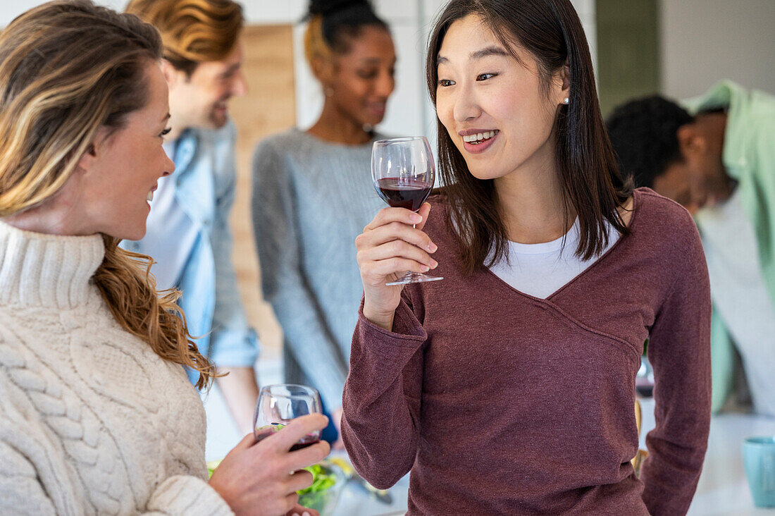 Two friends talking during reunion while drinking wine