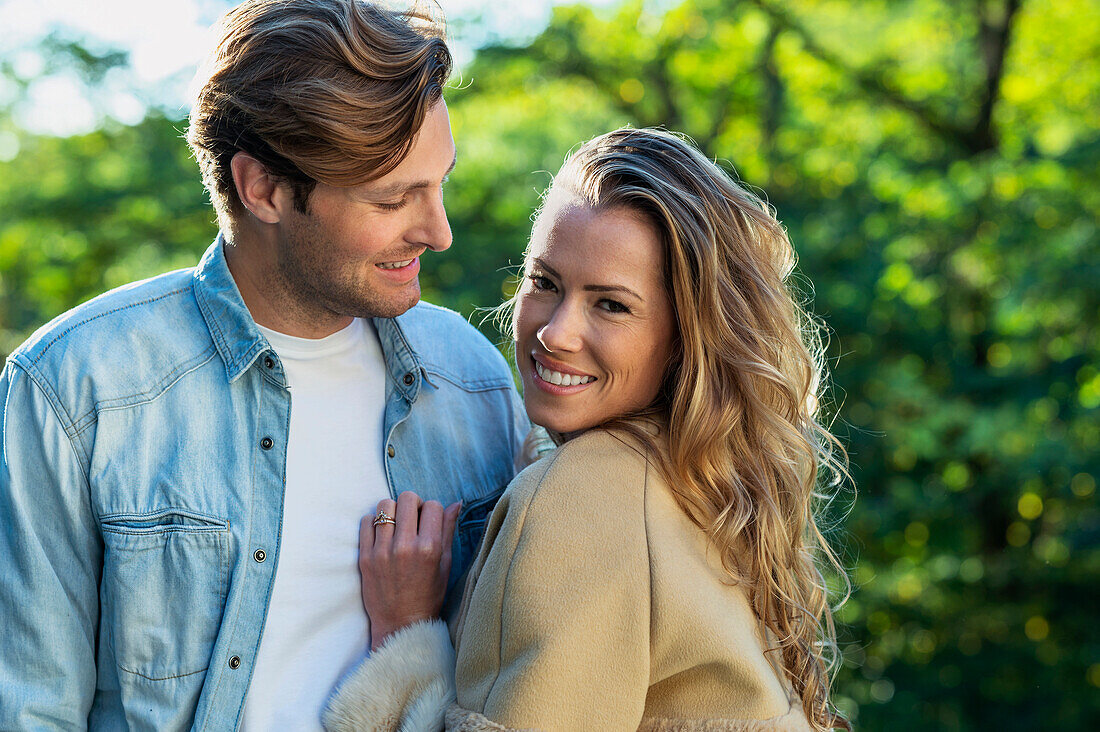 Beautiful woman looking at the camera while boyfriend is looking at her