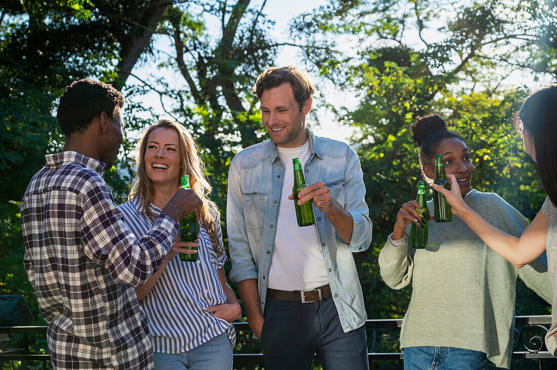 Gruppe von Freunden, die im Freien stehen und Bier trinken