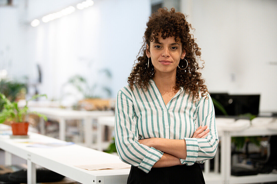 Confident businesswoman standing indoors while looking at the camera