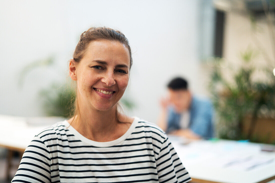 Female architect looking and smiling at the camera while standing in office