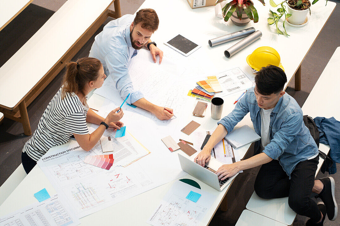 Gruppe von Architekten und Bauingenieuren, die ein Projekt besprechen