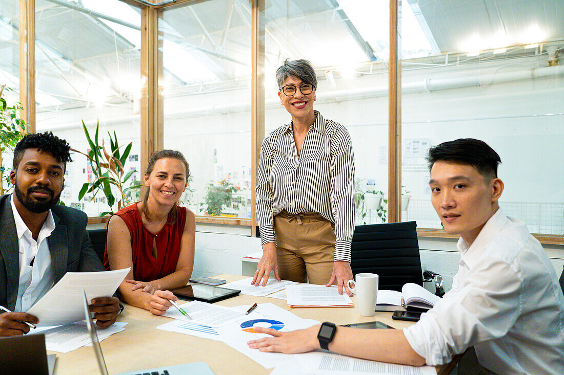 Businesswomen and businessmen looking at the camera during meeting