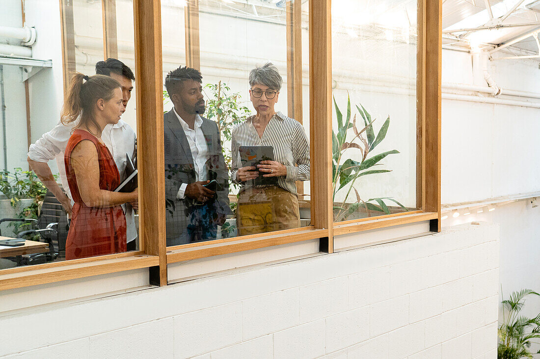 Geschäftsleute besprechen sich, während sie durch das Fenster schauen