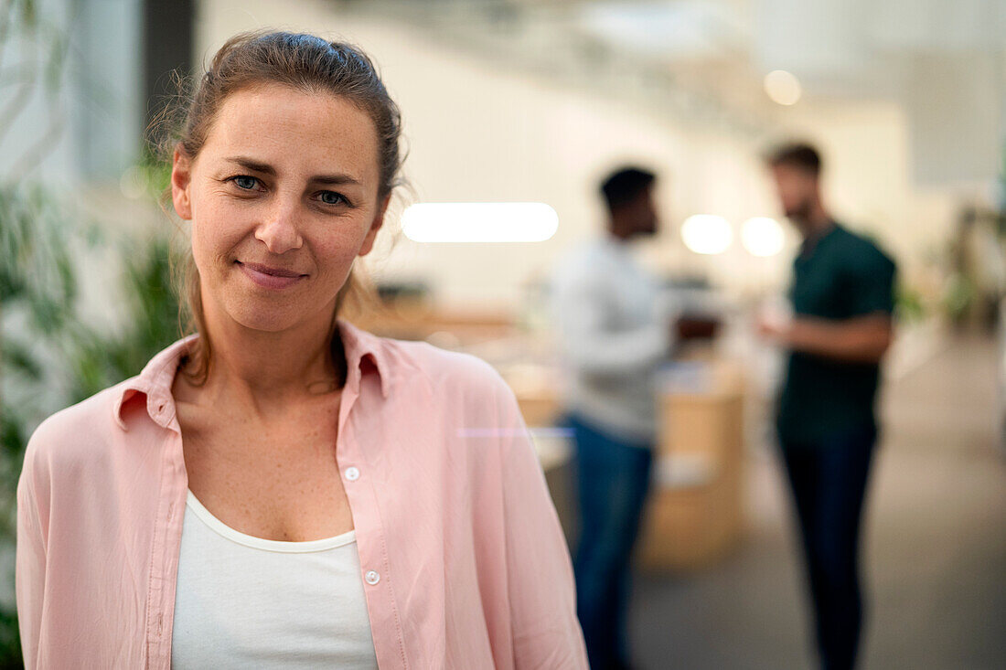 Adult woman smiling and looking at the camera while standing indoors