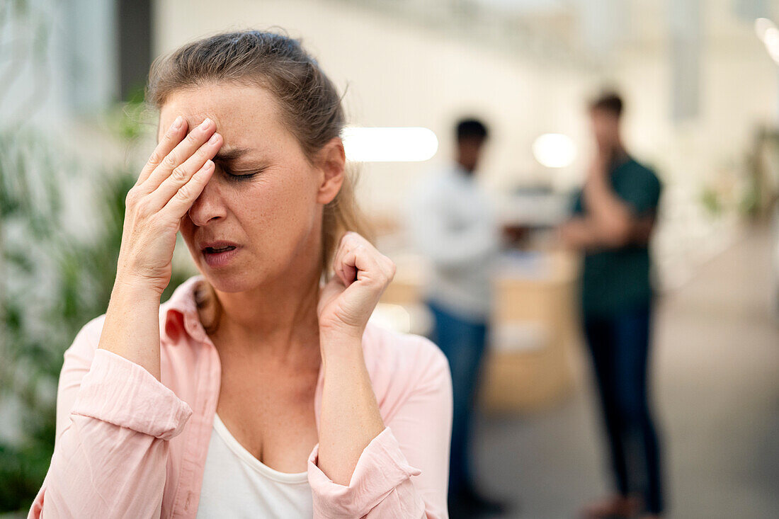 Weibliche Büroangestellte mit Kopfschmerzen