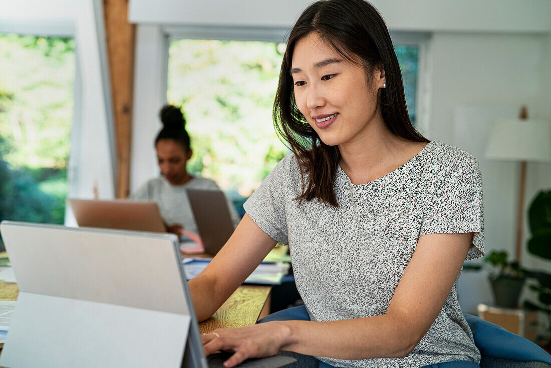 Female community manager using digital tablet while sitting at desk